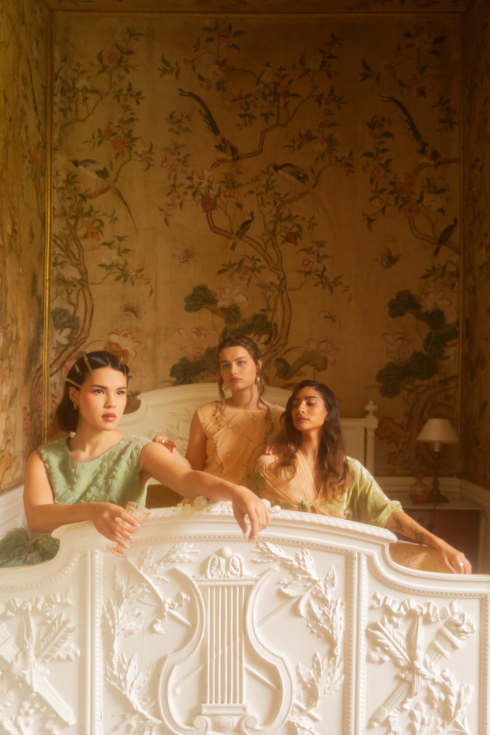 trois femmes sur un lit dans un manoir